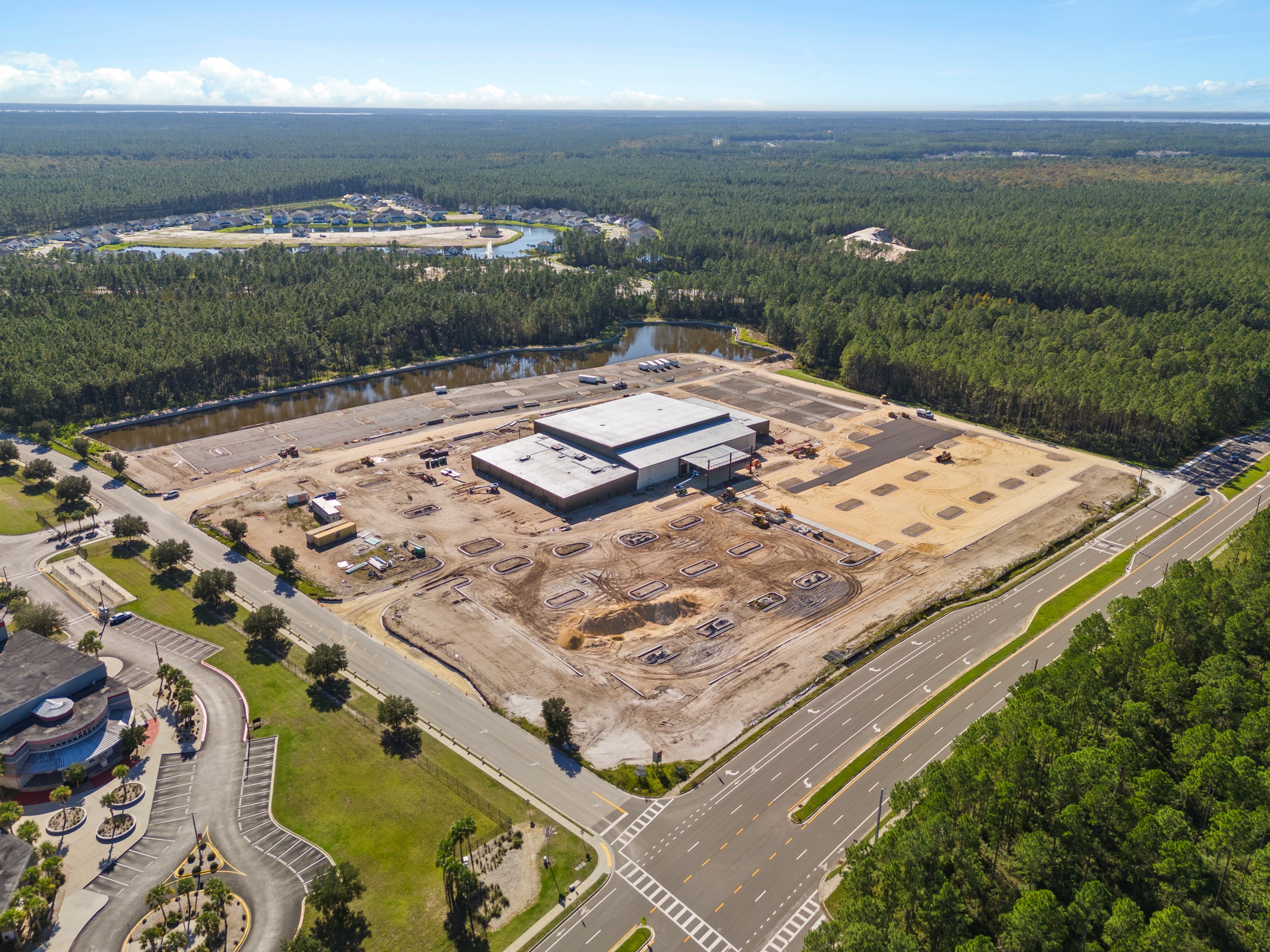 Aerial view of a new church campus under construction surrounded by forest