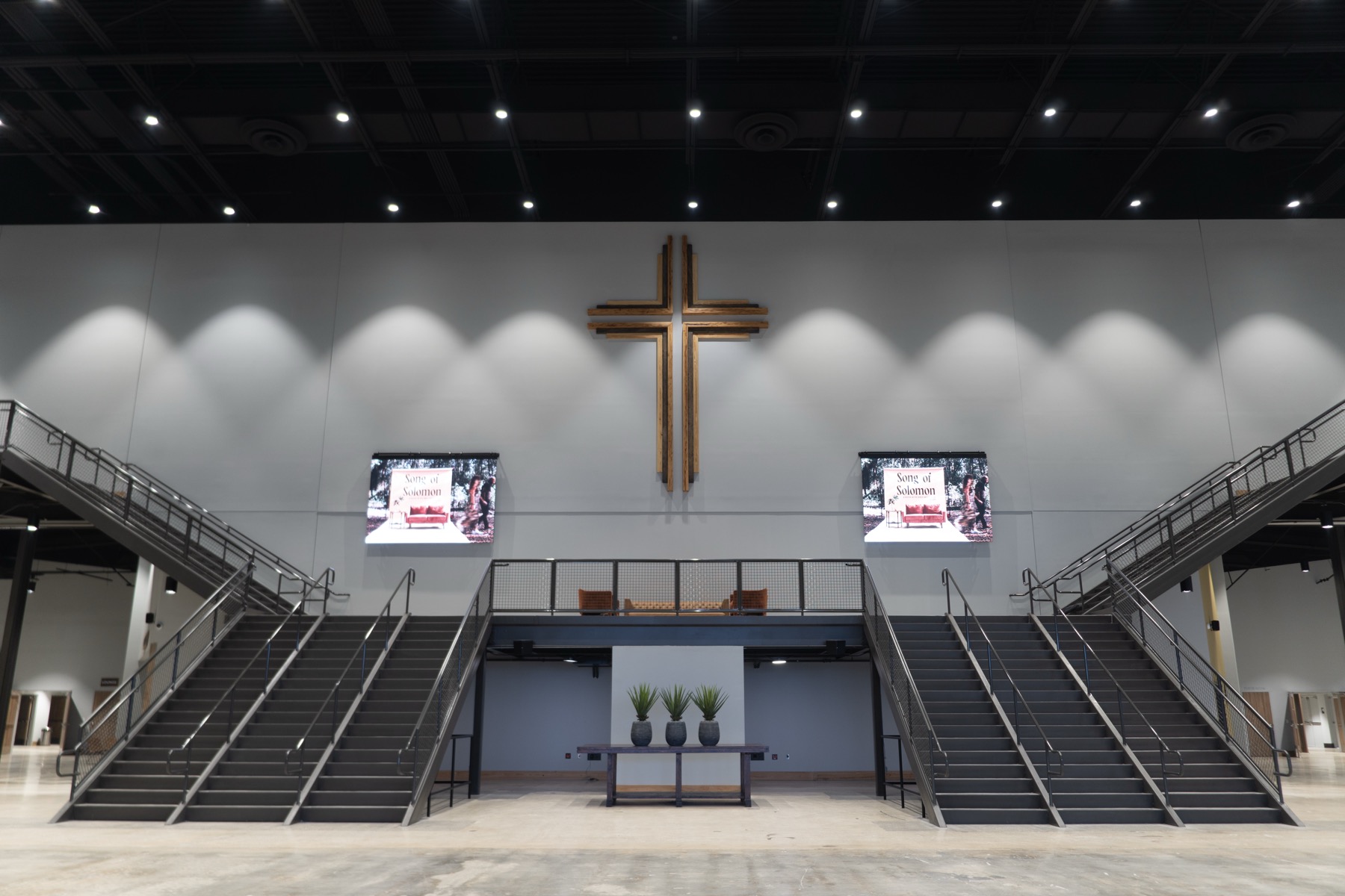 Finished church atrium with twin staircases and a large wooden cross