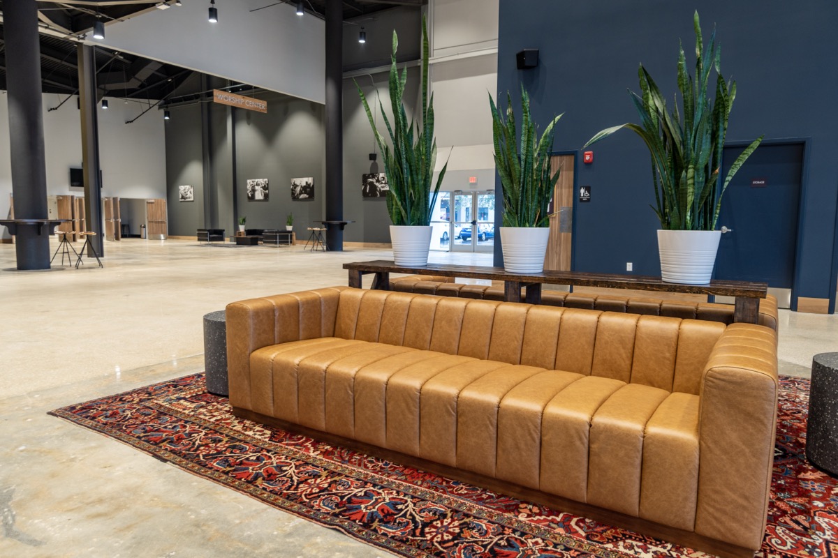Wide view of a finished church lobby with leather seating and planters